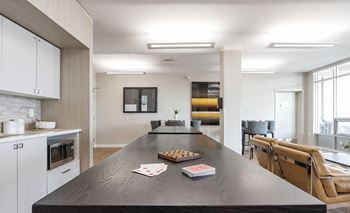 a kitchen with a long counter top next to a living room